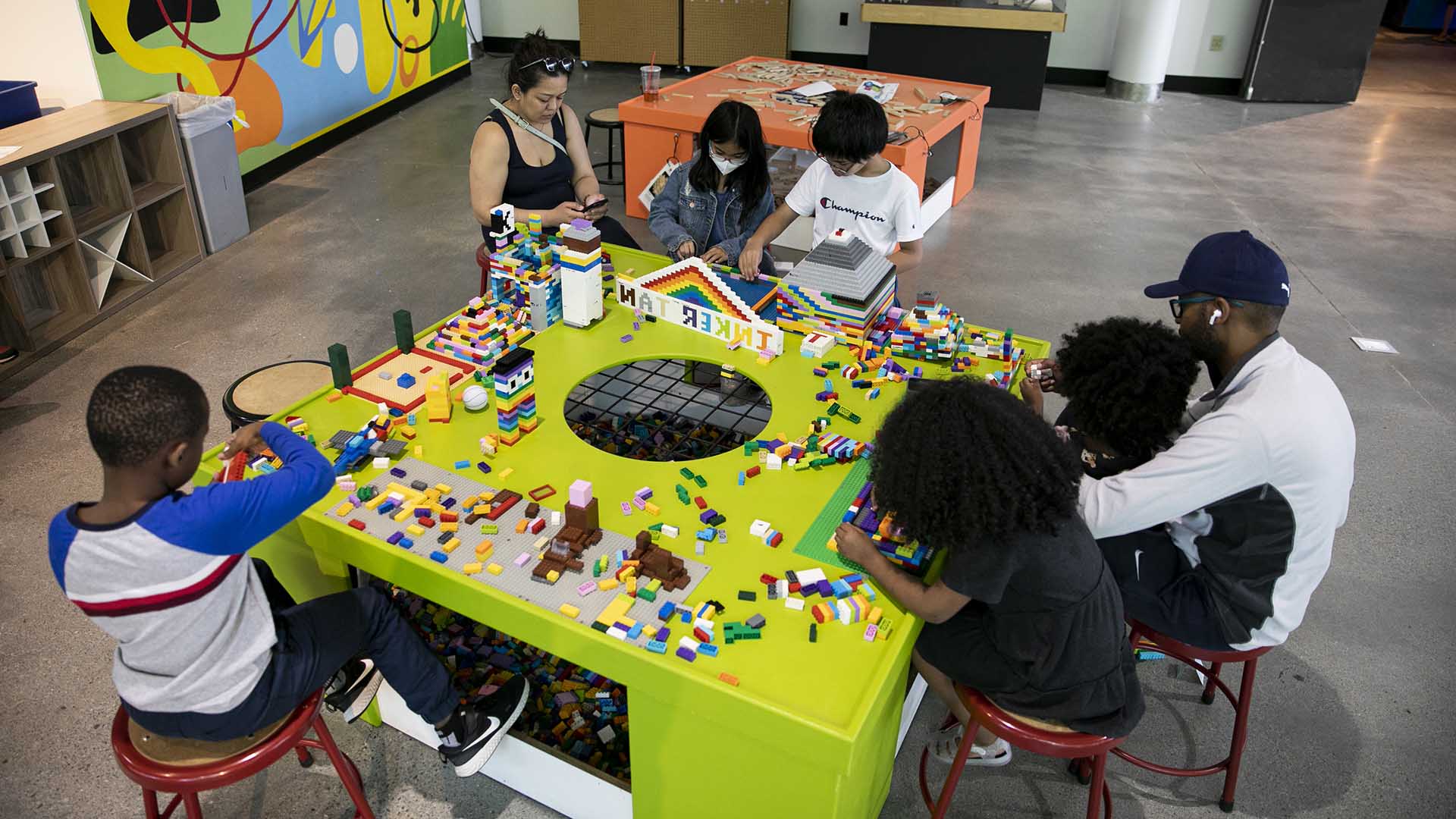 Children and their parents playing with LEGOs at Tinker Tank
