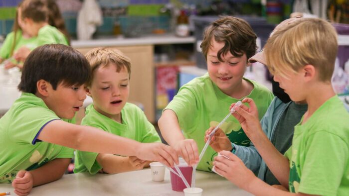 Four campers working with a beaker