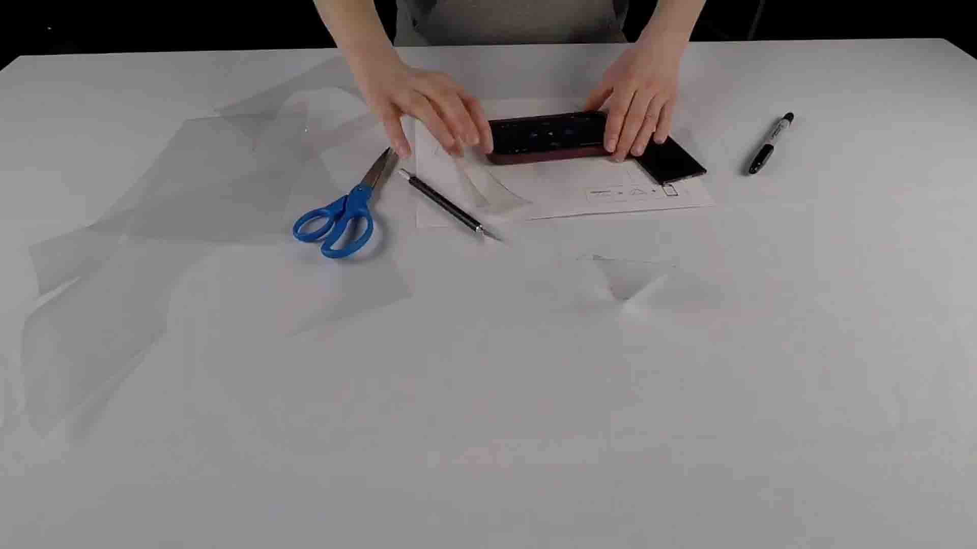 Scissors, smart phone on a table used to create a hologram
