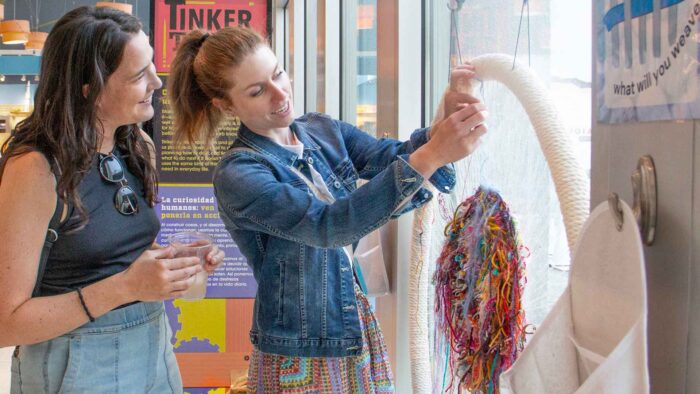 Two women in Tinker Tank working with yarn