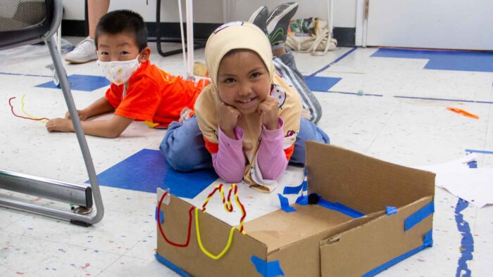 Two children are creating cardboard projects