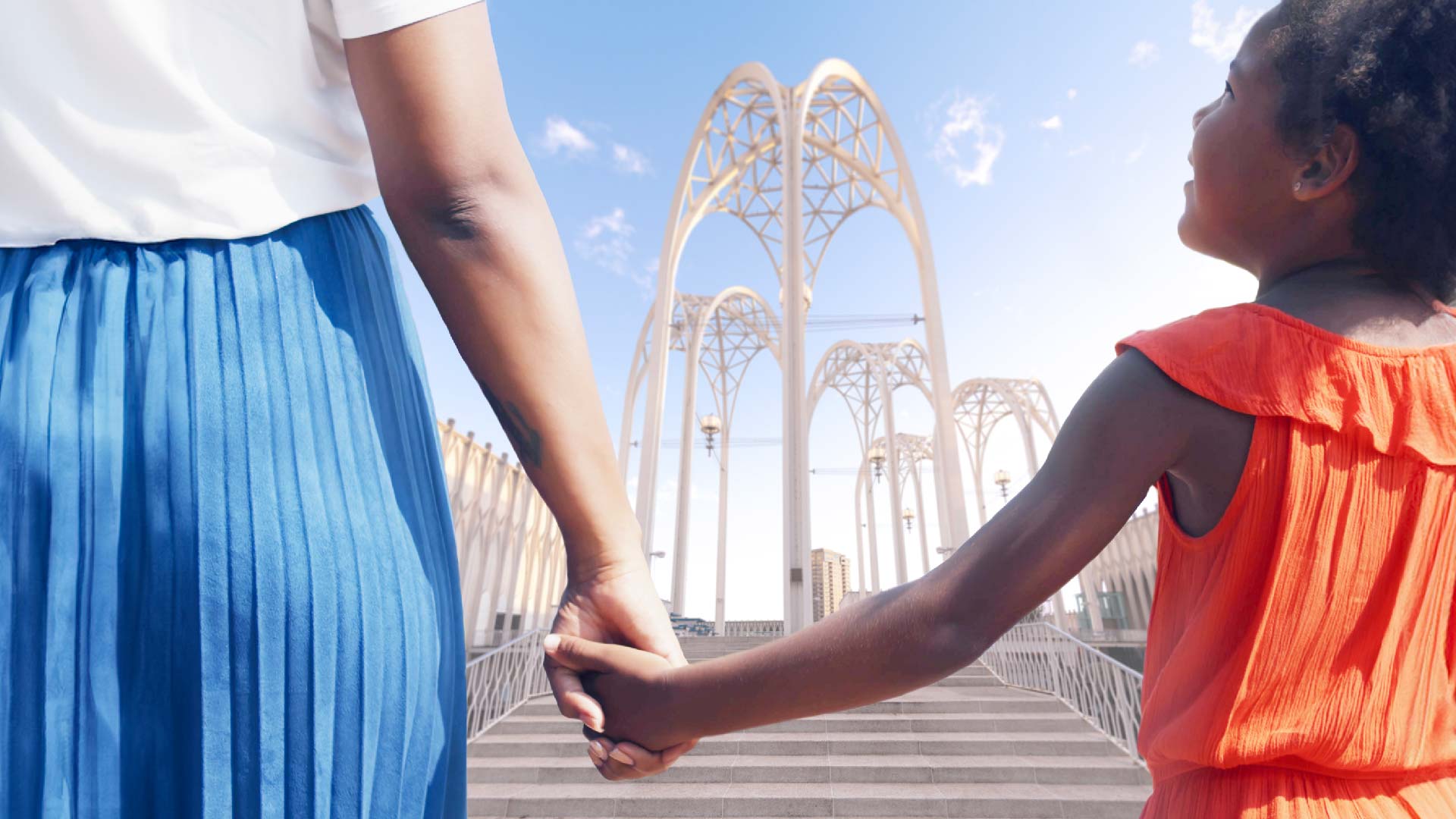 Mother and daughter holding hands with PacSci arches in background