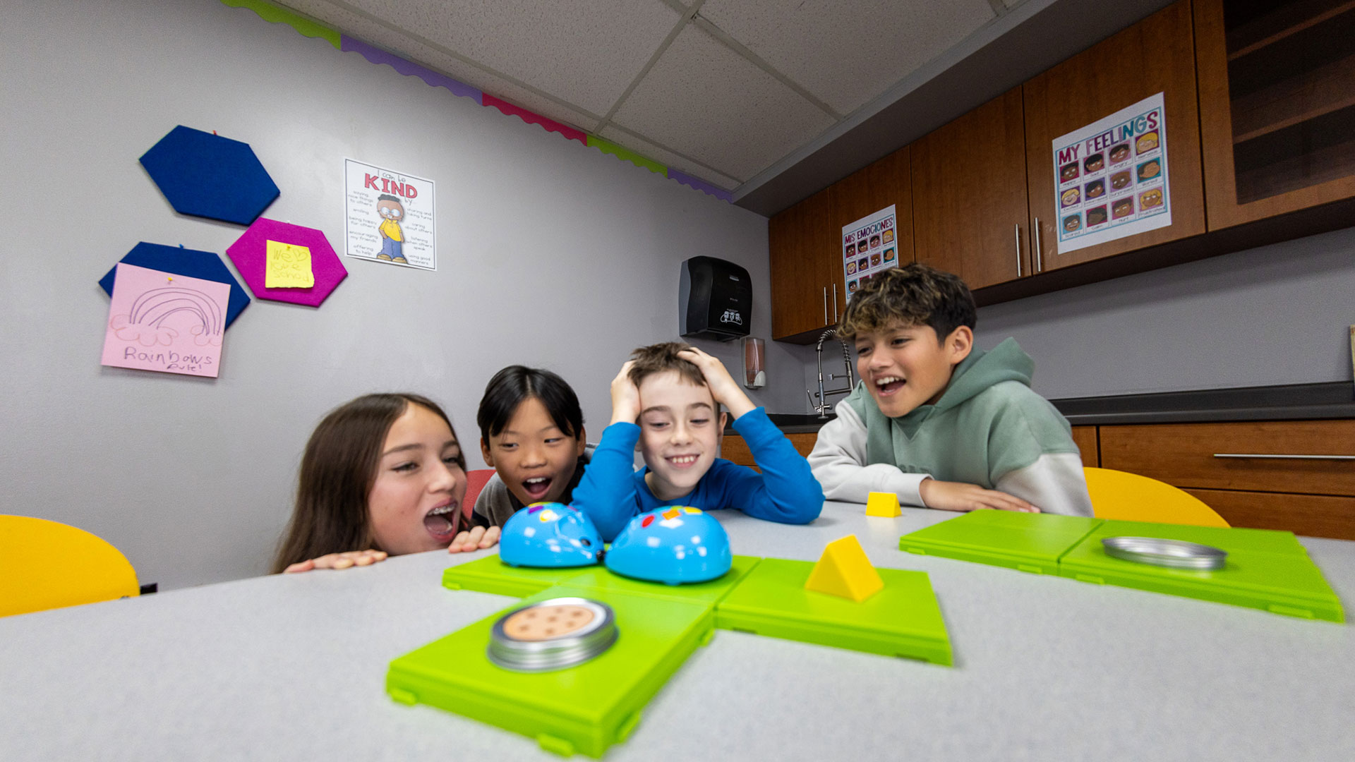 four kids looking at experiments