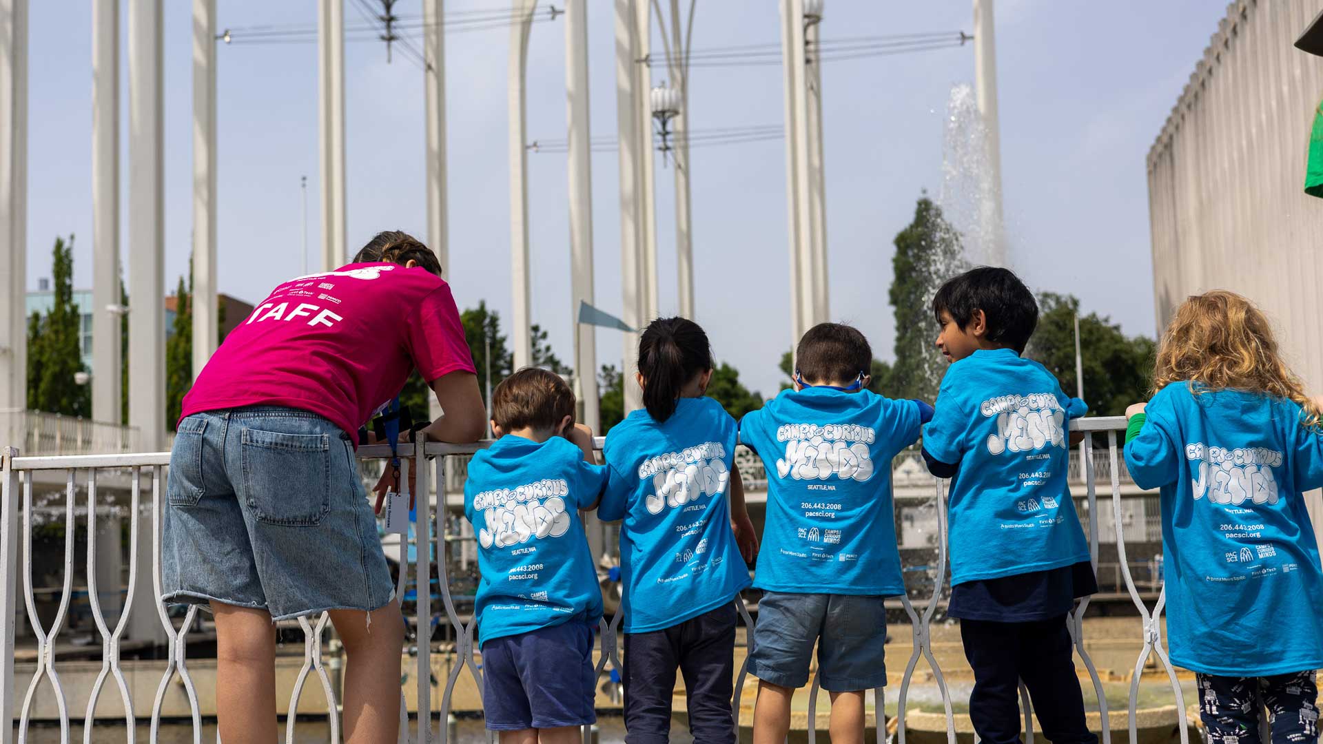 PacSci camp staff with five campers looking in the PacSci ponds