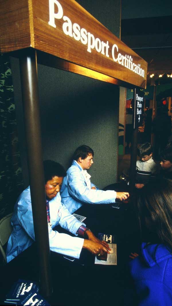 Two people at a booth "Passport Certification"