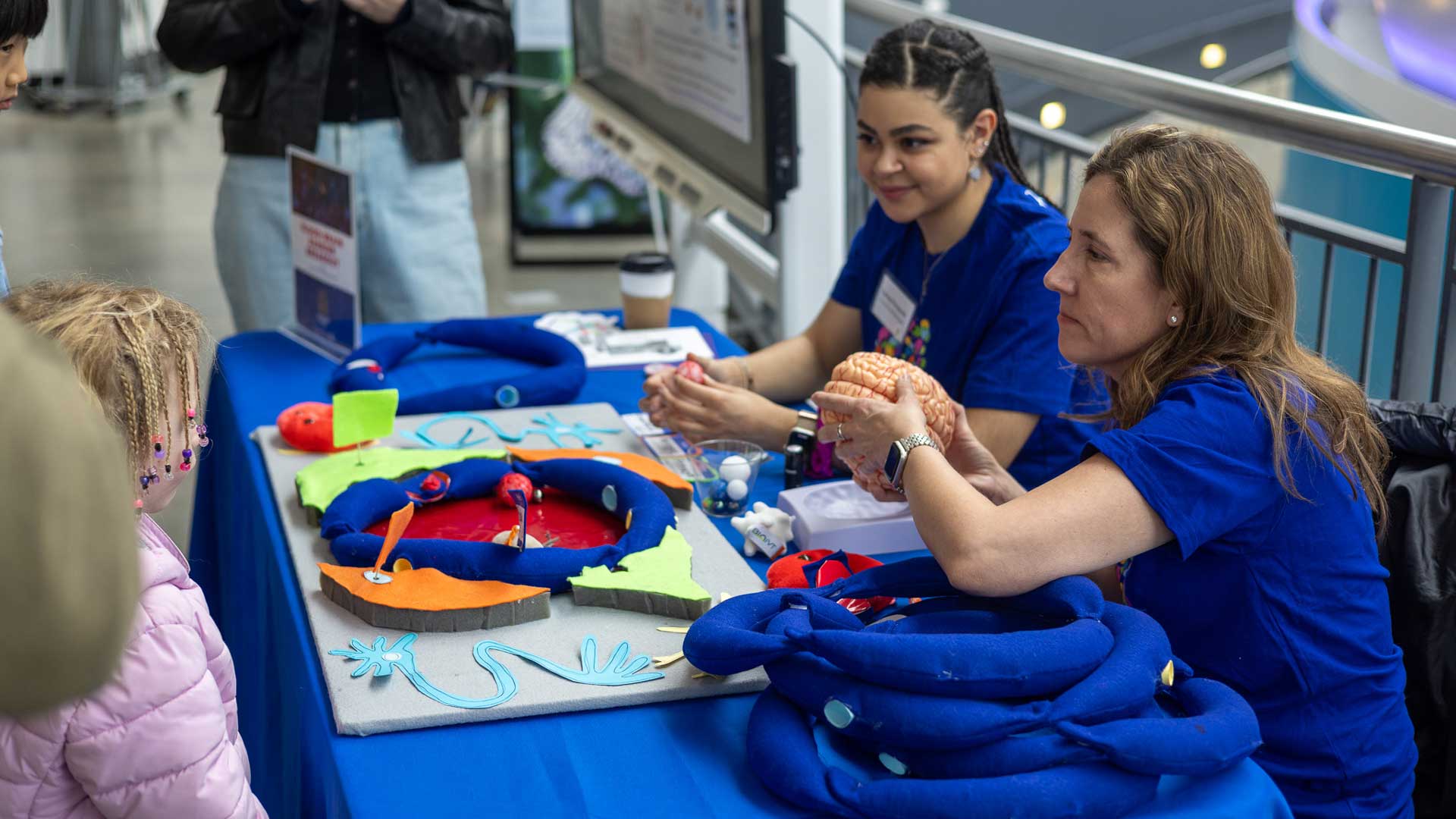 Two volunteers talk to children at a table