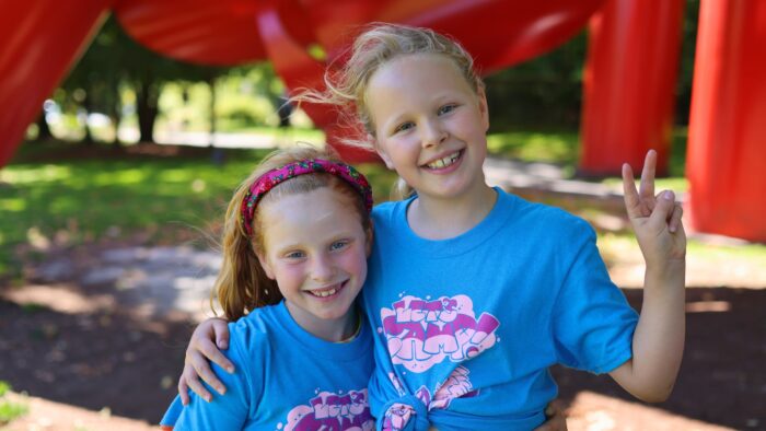 Two young girls smiling at camp